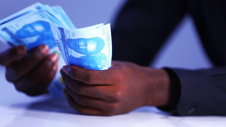 image of a man's hand holding the nigerian Naira